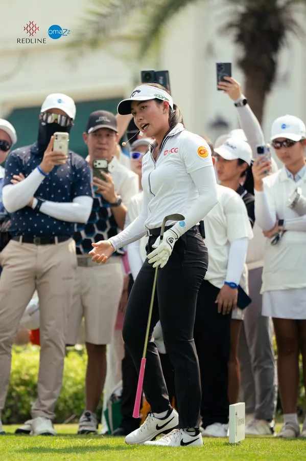 A golfer walking through a crowd with phones raised